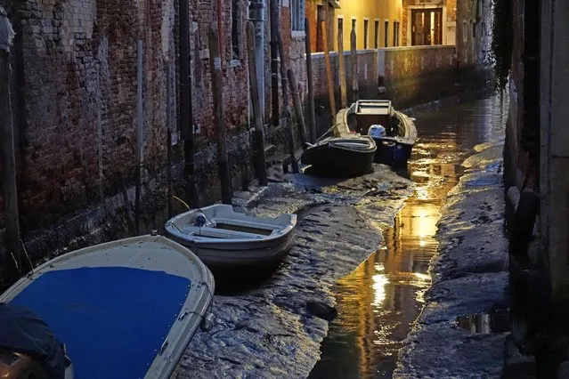 Boats sit on the muddy sea bed of the Venetian lagoon in the Rio dei Meloni area, in Venice, Thursday, December 29, 2016. An uncommon low tide hampered boat circulation in many areas of the city that is built on an archipelago where canals serve the function of roads. (Photo by Andrea Merola/ANSA via AP)