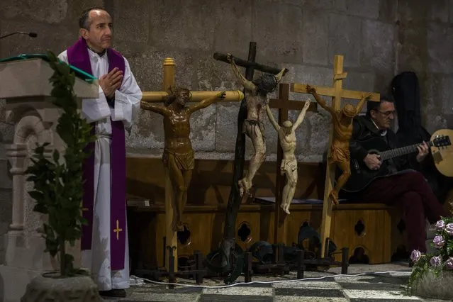 A member of a church prays during a Mass as penitents from “Las Siete Palabras (Seven words)” brotherhood get ready to take part in a procession in Zamora, Spain, on the early hours of Wednesday, April 1, 2015. (Photo by Andres Kudacki/AP Photo)