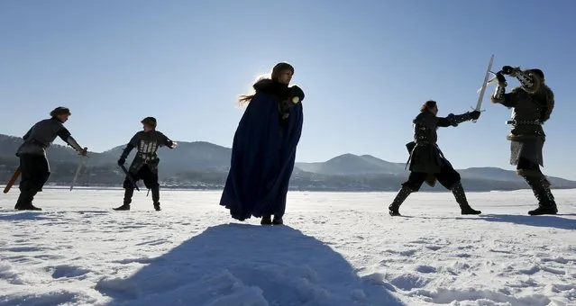 Members of the “Grifon” (Griffin) amateur club of artistic fencing, dressed as medieval East European soldiers and a woman, participate in a performance entitled “Duel for the lady's heart” to mark Valentine's Day near an Orthodox monastery on the bank of the Yenisei River on the surburbs of Krasnoyarsk, Russia, February 14, 2016. (Photo by Ilya Naymushin/Reuters)