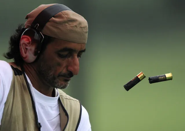 Ahmed Almaktoum of the UAE unloads his shotgun during the qualifying round of the men's trap competition of the shooting event at the Beijing 2008 Olympic Games. August 2008. (Photo by Desmond Boylan/Reuters)