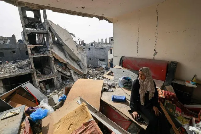 A Palestinian wopman sits on debris in her damaged apartment in the Khezaa district on the outskirts of the southern Gaza Strip city of Khan Yunis, following weeks of Israeli bombardment, as a truce between Israel and Hamas entered its second day on November 25, 2023. Hamas is expected to release another 14 Israeli hostages in exchange for 42 Palestinian prisoners on November 25, as part of a four-day truce in their seven-week war. (Photo by Mahmud Hams/AFP Photo)