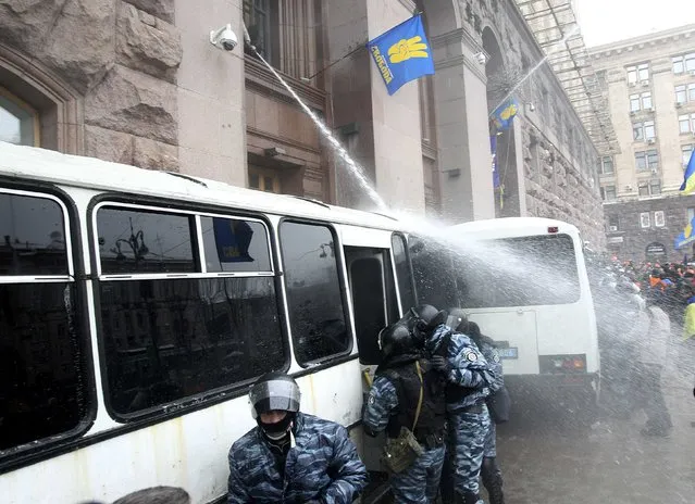 Protesters spray riot police with water hose to prevent it from entering the City Hall in Kiev December 11, 2013. Scores of Ukrainian riot police withdrew on Wednesday morning from a protest camp after moving against protesters overnight in the authorities' biggest attempt yet to disburse weeks of protests against President Viktor Yanukovich. (Photo by Valentin Ogirenko/Reuters)