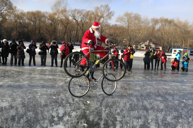 A man dressed as Santa Claus performs stunt with bicycles on ice, in Changchun, Jilin province, China December 15, 2015. (Photo by Reuters/China Daily)