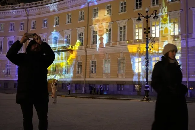 Russian President Vladimir Putin's New Year's message is projected onto a wall during New Year's celebrations at the Palace Square in St. Petersburg, Russia, Sunday, December 31, 2023. (Photo by Dmitri Lovetsky/AP Photo)