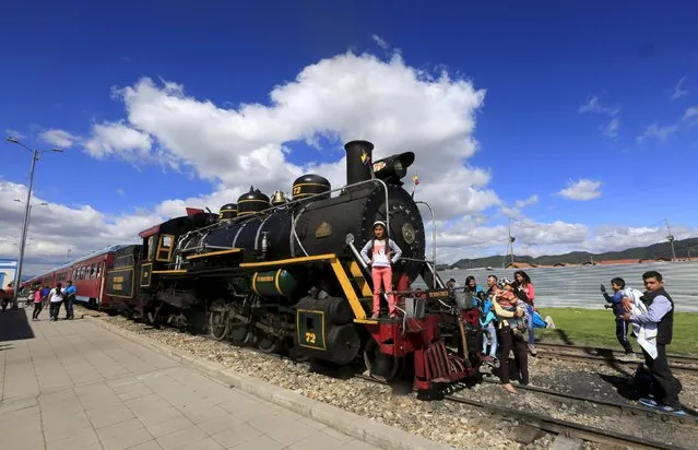 A girl poses for a photo as the “La Sabana” tourist train makes a stop in Cajica, March 8, 2015. The “La Sabana” tourist train that runs through the capital was founded by Eduardo Rodriguez, a railway engineer. Rodriguez has worked on Colombia's railway system his whole life and now, with an air of nostalgia, transports thousands of tourists in renovated steam locomotives that he fixes in Bogota's Central Station which dates back to 1913. (Photo by Jose Miguel Gomez/Reuters)