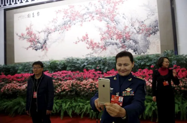 A military delegate takes pictures with her mobile phone ahead of the opening session of the Chinese People's Political Consultative Conference (CPPCC) at the Great Hall of the People in Beijing, China, March 3, 2016. (Photo by Kim Kyung-hoon/Reuters)