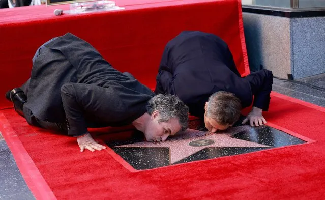 US actor Mark Ruffalo (L) and US actor Willem Dafoe kiss Dafoe's newly unveiled star during the ceremony honoring him with a Hollywood Walk of Fame star in Hollywood, California, on January 8, 2024. (Photo by Michael Tran/AFP Photo)