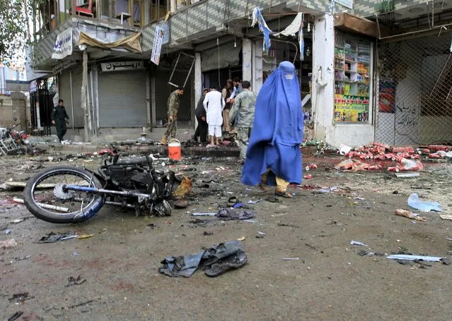 An Afghan woman walks at the site of a suicide attack in Jalalabad April 18, 2015. The suicide bomb blast in Afghanistan's eastern city of Jalalabad killed 33 people and injured more than 100 outside a bank where government workers collect salaries, the city's police chief said on Saturday. (Photo by Reuters/Parwiz)