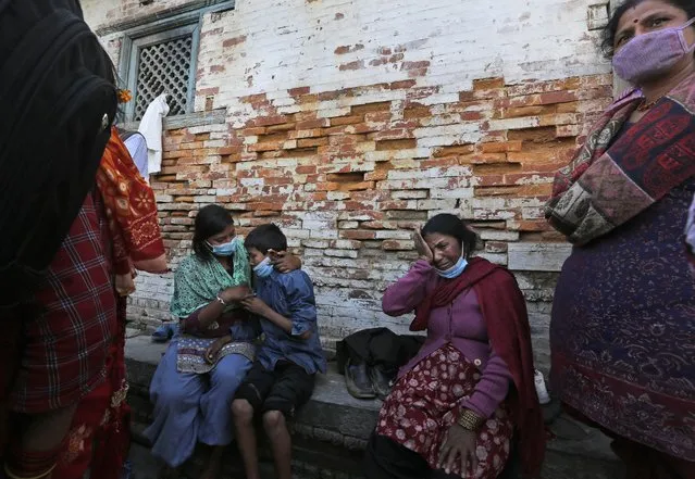 A Nepalese family mourns during the cremation of their relative killed in the recent earthquake, at the Pashupatinath temple, on the banks of Bagmati river, in Kathmandu, Nepal, Monday, April 27, 2015. (Photo by Manish Swarup/AP Photo)