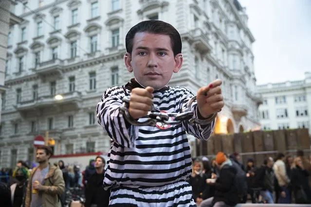 A demonstrator dresses up as Austrian Chancellor Sebastian Kurz in handcuffs attends a protest against the  Chancellor in fronton  the headquarters the Austrian Peoples Party party in Vienna, Austria, Thursday, October 7, 2021. (Photo by Lisa Leutner/AP Photo)