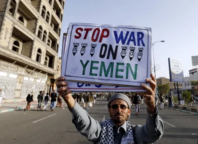 A follower of the Houthi group holds up a sign at the site of a demonstration against the air strikes by the Saudi-led coalition in Sanaa April 27, 2015. (Photo by Khaled Abdullah/Reuters)