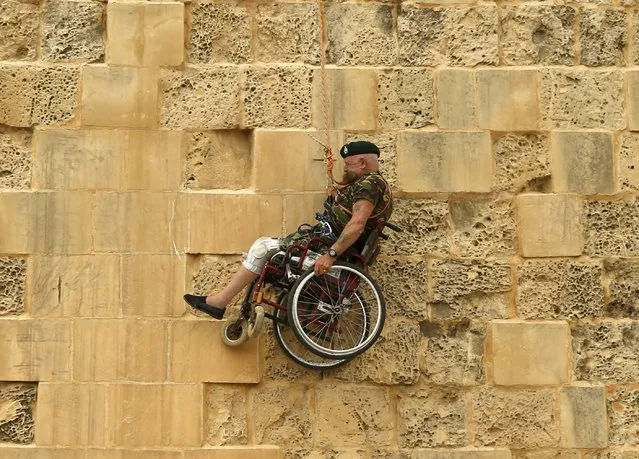 British former police officer Swasie Turner abseils for charity in a wheelchair down the fortification bastions of Valletta, Malta, April 27, 2015. (Photo by Darrin Zammit Lupi/Reuters)
