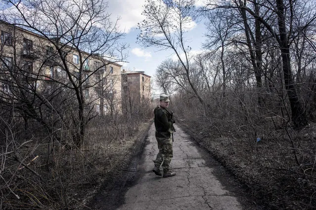 A Ukrainian solder patrols in the village of Zolote 4, eastern Ukraine, Friday, March 29, 2019.  Five years after a deadly separatist conflict in eastern Ukraine, a generation of first-time voters in the rebel-held Donetsk and Luhansk areas has been cut off from Sunday's Ukrainian presidential election. (Photo by Evgeniy Maloletka/AP Photo)