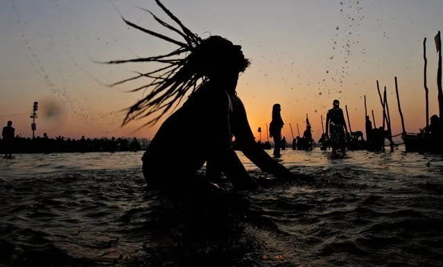 A Naga Sadhu, or Hindu holy naked man, takes holy dips at Sangam, confluence of Hindu holy rivers of Ganges, Yamuna and the mythical Saraswati, for a ritual dip, on the auspicious occasion of “Basant Panchami” at the annual traditional fair of Magh Mela in Allahabad, India, Tuesday, February 4, 2014. Basant Panchami, the fifth day of spring is celebrated by worshipping Hindu Goddess of knowledge and wisdom, Saraswati. (Photo by Rajesh Kumar Singh/AP Photo)