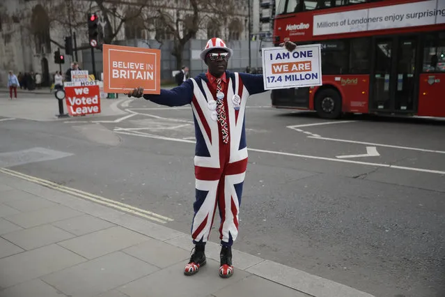 A pro-Brexit leave the European Union supporter holds up placards outside the Houses of Parliament in London, Wednesday, April 3, 2019. After failing repeatedly to win Parliament's backing for her Brexit blueprint, Britain's Prime Minister Theresa May dramatically changed gear Tuesday, saying she would seek to delay Brexit – again – and hold talks with the opposition to seek a compromise. (Photo by Matt Dunham/AP Photo)