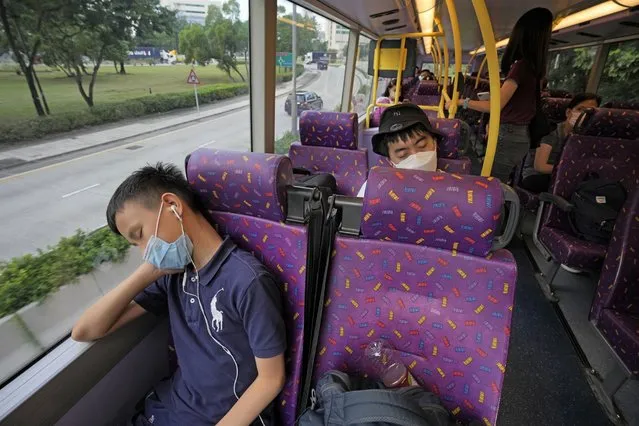 Passengers sleep on the upper deck of a double-decker bus in Hong Kong, Saturday, October 16, 2021. Travel-starved, sleep-deprived residents might find a new Hong Kong bus tour to be a snooze. The 47-mile, five-hour ride on a double-decker bus around the territory is meant to appeal to people who are easily lulled asleep by long rides. (Photo by Kin Cheung/AP Photo)