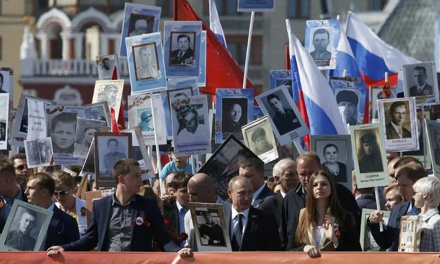 Russian President Vladimir Putin (C) holds the portrait of his father as he takes part in the Immortal Regiment march with pictures of World War Two soldiers on Red Square during the Victory Day celebrations in Moscow, Russia, May 9, 2015. (Photo by Grigory Dukor/Reuters)