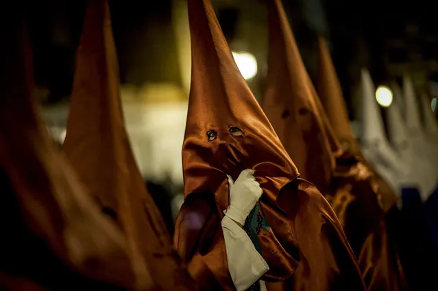 Masked penitents take part in the procession of the “Santa Veracruz” brotherhood, during Holy Week in Calahorra, northern Spain, Wednesday, March 24, 2016. (Photo by Alvaro Barrientos/AP Photo)