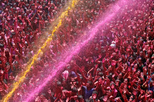 Devotees are sprayed with coloured water inside temple premises during Holi celebrations in Ahmedabad, India. (Photo by Amit Dave/Reuters)