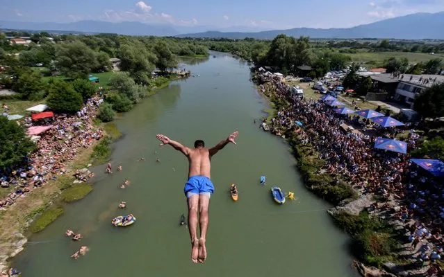 A man jumps from the 22 meters high bridge “Ura e Shenjte” during the annual traditional High Diving competition near the town of Gjakova on July 22, 2019. (Photo by Armend Nimani/AFP Photo)