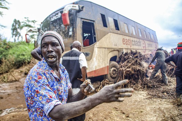 People try to clear a bus that was washed away after a dam burst in Kamuchiri Village Mai Mahiu, Nakuru County, Kenya, Monday, April. 29, 2024. Kenya's Interior Ministry says at least 45 people have died and dozens are missing after a dam collapsed following heavy rains. (Photo by Patrick Ngugi/AP Photo)