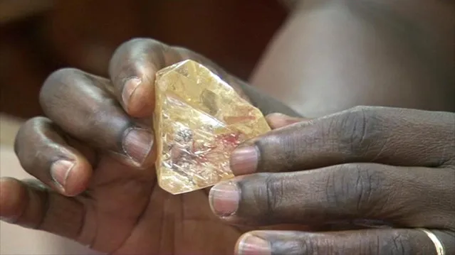 In this photo taken from video footage, Sierra Leone's President Ernest Bai Koroma hands a diamond during a meeting with delegates of Kono district, where the gem was found, at the presidential office in Freetown, Sierra Leone, Thursday, March 16, 2017. A pastor in Sierra Leone has discovered the largest uncut diamond found in more than four decades in this West African country and has turned it over to the government, saying he hopes it helps to boost recent development in his impoverished nation. (Photo by SLBC via AP Photo)