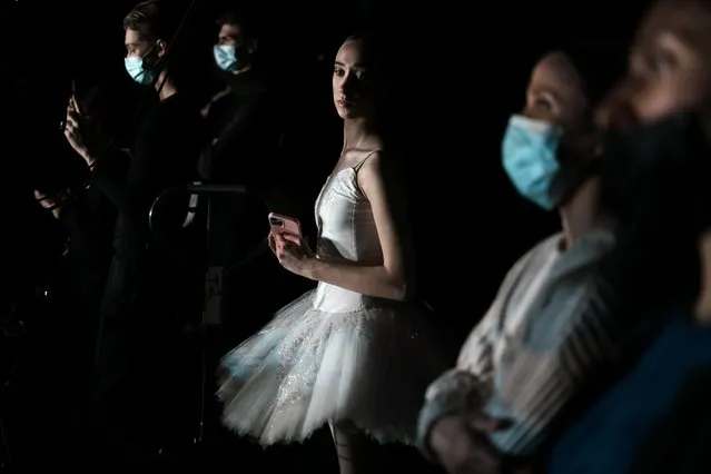 A Ukrainian dancer of the Kyiv City Ballet company waits backstage during a performance at the Theatre de Chatelet, in Paris, Tuesday, March 8, 2022. The Kyiv City Ballet danced to a full house in Paris for the last show of a French tour that has left the company stranded after the war broke out in Ukraine. They described being physically and emotionally exhausted. Being given the opportunity to train and dance was for many a chance to focus on something other than the war. (Photo by Thibault Camus/AP Photo)