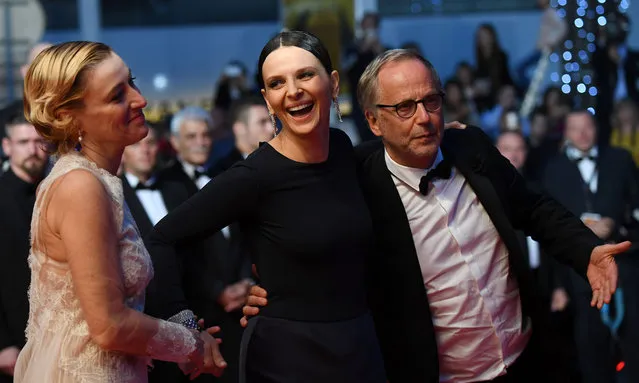 (From L): Italian actress Valeria Bruni Tedeschi, French actress Juliette Binoche and French actor Fabrice Luchini pose on May 13, 2016 as they leave the Festival Palace after the screening of the film “Ma Loute (Slack Bay)” at the 69th Cannes Film Festival in Cannes, southern France. (Photo by Anne-Christine Poujoulat/AFP Photo)