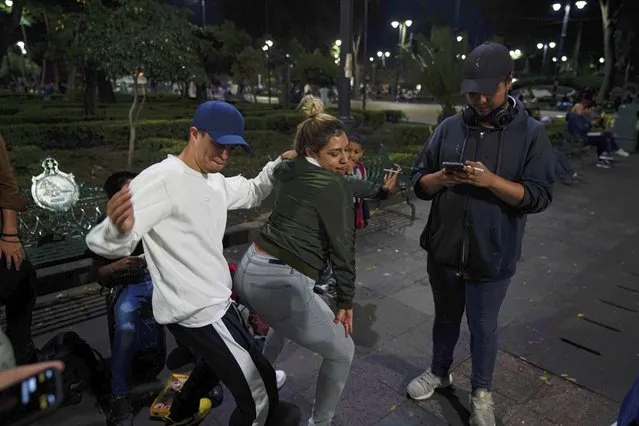 Youths dance during a rap performance at a plaza in the Coyoacan neighborhood of Mexico City, Friday, July 23, 2021. Hours after Mexico City authorities raised the alert level in the face of rising COVID-19 infections, many residents of the capital's trendy Coyoacan neighborhood crammed its center ignoring social distancing and forgoing masks. (Photo by Fernando Llano/AP Photo)