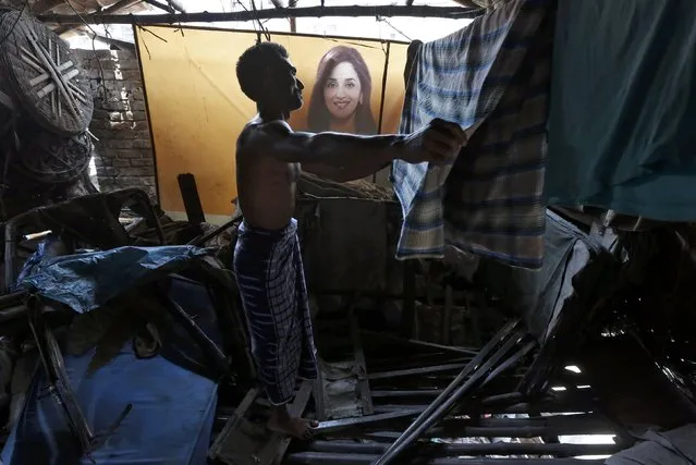 A rickshaw puller hangs a cloth to dry next to an image of Bollywood actress Madhuri Dixit inside his shelter in Kolkata, India, May 3, 2016. Picture taken May 3, 2016. (Photo by Rupak De Chowdhuri/Reuters)