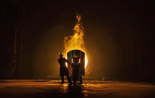 A worker takes samples for quality of molten iron outside a furnace at the Zhong Tian (Zenith) Steel Group Corporation on May 12, 2016 in Changzhou, Jiangsu. Zhong Tian (Zenith) Steel Group Corporation is a privately-owned manufacturer that employs over 13,000 workers at its facility in China's eastern Jiangsu province. Since 2001, the company says it has adopted new technology to streamline the production of premium quality steel and to reduce environmental impact. The majority of its steel output is for the Chinese market with 20% earmarked for export, mostly to Asia. (Photo by Kevin Frayer/Getty Images)