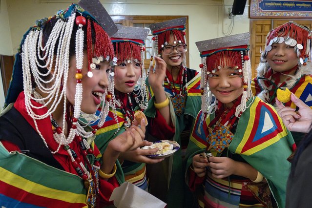 Exiled Tibetan school girls in a traditional costumes eat cakes and sweets as they wait to perform a traditional dance at an event to celebrate the 89th birthday of Tibetan spiritual leader the Dalai Lama at the Tsuglakhang temple in Dharamshala, India, Saturday, July 6, 2024. (Photo by Ashwini Bhatia/AP Photo)