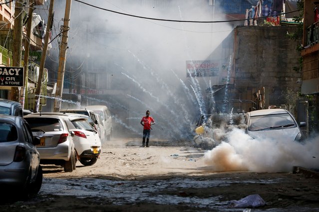 A man stands as riot police use teargas to disperse protesters during an anti-government demonstration following nationwide deadly riots over tax hikes, within Pipeline estate near the Jomo Kenyatta International airport (JKIA) in Nairobi, Kenya on July 23, 2024. (Photo by Thomas Mukoya/Reuters)