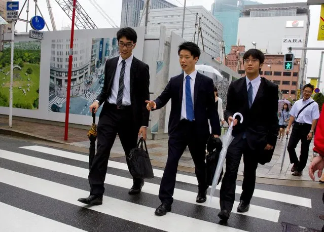 Young businessmen cross a street during lunch hour in Tokyo July 1, 2015. (Photo by Thomas Peter/Reuters)