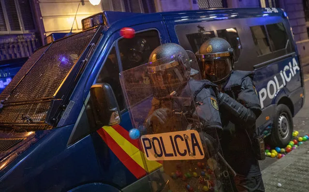 National police are hit by plastic balls thrown by demonstrators during a demonstration in Barcelona, Spain, Saturday, October 26, 2019. Protests turned violent last week after Spain's Supreme Court convicted 12 separatist leaders of illegally promoting the wealthy Catalonia region's independence and sentenced nine of them to prison. (Photo by Emilio Morenatti/AP Photo)