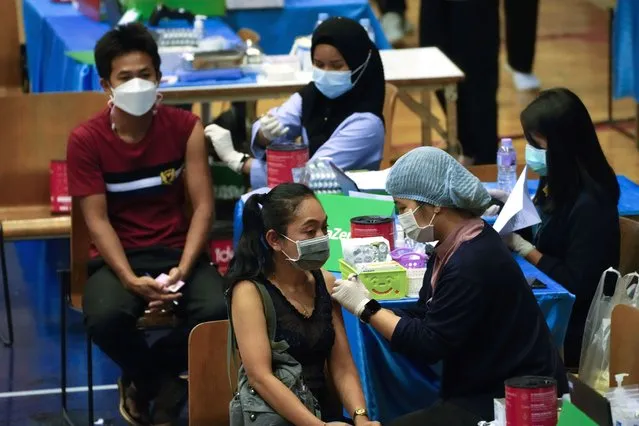 A health worker administers a dose of the AstraZeneca COVID-19 vaccine to a woman in Bangkok, Thailand, Wednesday, February 23, 2022. (Photo by Sakchai Lalit/AP Photo)