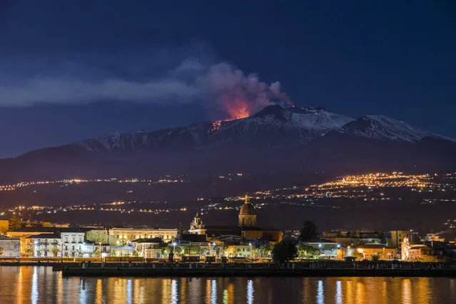 Mount Etna, Europe's most active volcano, spews lava as the Sicilian town of Riposto, Italy, is visible in foreground, during an eruption in the early hours of Tuesday, April 11, 2017. (Photo by Salvatore Allegra/AP Photo)
