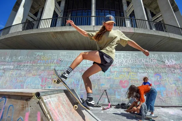 Youths skateboard outside the country's parliament after the surrounding grounds were occupied by anti-vaccine demonstrators in Wellington on February 22, 2022. (Photo by Dave Lintott/AFP Photo)
