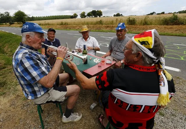 A man plays trumpet as he waits the 8th stage of the 102nd Tour de France cycling race from Rennes to Mur-de-Bretagne, France, July 11, 2015. (Photo by Stefano Rellandini/Reuters)