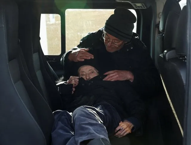 A disabled 88-year-old Ukrainian refugee, who said she also had to flee from the Nazis in 1941, lies in a vehicle operated by the U.S. humanitarian organization Operation Blessing, after crossing the Ukraine-Poland border, in Medyka, Poland, April 19, 2022. (Photo by Darrin Zammit Lupi/Reuters)