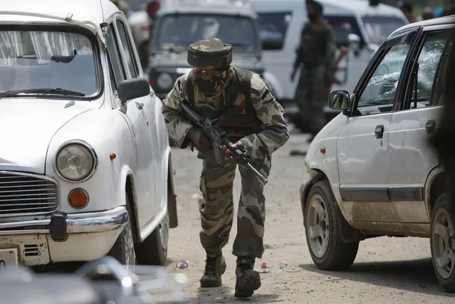 An Indian army soldier takes position during a fight in the town of Dinanagar, in the northern state of Punjab, India, Monday, July 27, 2015. (Photo by Channi Anand/AP Photo)