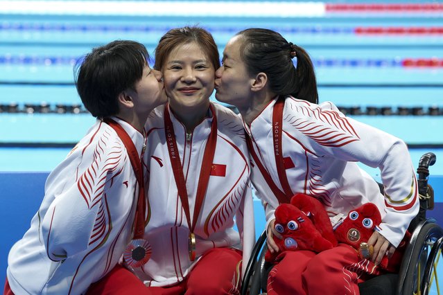 Lu Dong, He Shenggao and Liu Yu, of China, celebrate their first, second and third position at the podium of Women's 50m Backstroke -S5 during the 2024 Paralympics, Tuesday, September 3, 2024, in Paris, France. (Photo by Jackson Ranger/AP Photo)