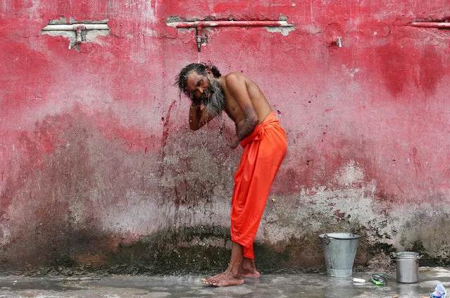 A Sadhu or a Hindu holy man bathes before registering for the annual pilgrimage to the Amarnath cave shrine, at a base camp in Jammu June 27, 2017. (Photo by Mukesh Gupta/Reuters)