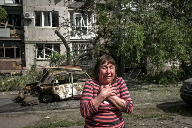 A woman reacts outside a damaged appartment building after a strike in the city of Slovyansk at the eastern Ukrainian region of Donbas on May 31, 2022, amid Russian invasion of Ukraine. (Photo by Aris Messinis/AFP Photo)