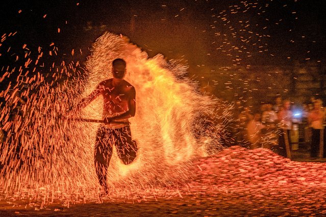 The photo taken on September 17, 2024 shows a villager walking over burning charcoal to perform a traditional fire-walking ritual called “Lianhuo” at Shuangfeng village in Jinhua, in eastern China's Zhejiang province. (Photo by AFP Photo/China Stringer Network)