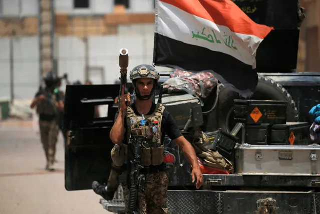 A member of the Iraqi security forces carries his weapon at Falluja hospital in center of Falluja, Iraq, June 20, 2016. (Photo by Thaier Al-Sudani/Reuters)