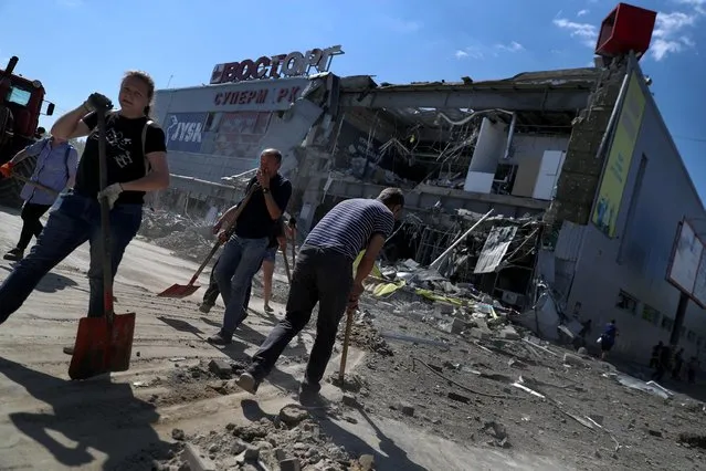 Local residents remove debris from a supermarket in a shopping mall damaged by a Russian missile strike, as Russia's attack on Ukraine continues, in Kharkiv, Ukraine on June 8, 2022. (Photo by Ivan Alvarado/Reuters)