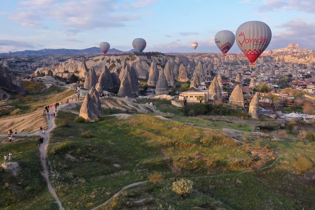 A view of hot air balloons flying over valleys of Cappadocia during sunrise in Goreme district of Nevsehir, Turkiye on April 11, 2024. Local tourists who came to Cappadocia for the Eid al-Fitr holiday showed interest in the balloon tour at sunrise. (Photo by Behcet Alkan/Anadolu via Getty Images)