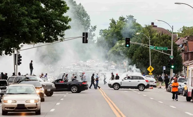 Smoke rises as police attempt to disperse protesters on Page  Ave. after a shooting incident in St. Louis, Missouri August 19, 2015. (Photo by Kenny Bahr/Reuters)