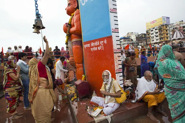 Hindu pilgrims offer prayers to an idol of monkey God Hanuman as they gather next to the Godavari River during Kumbh Mela, or Pitcher Festival, celebrations in Nasik, India, Wednesday, August 26, 2015. (Photo by Bernat Armangue/AP Photo)